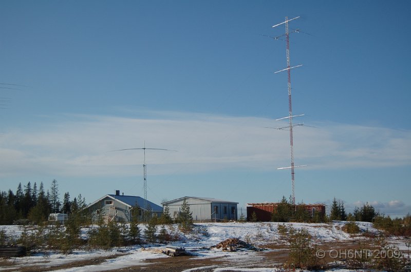 DSC_1484.JPG - versiktsbild mot stationshusen med mast #1 (105 meter) i bakgrunden (4 x 5 ele 20 m + 2 x 2 ele 80 m)